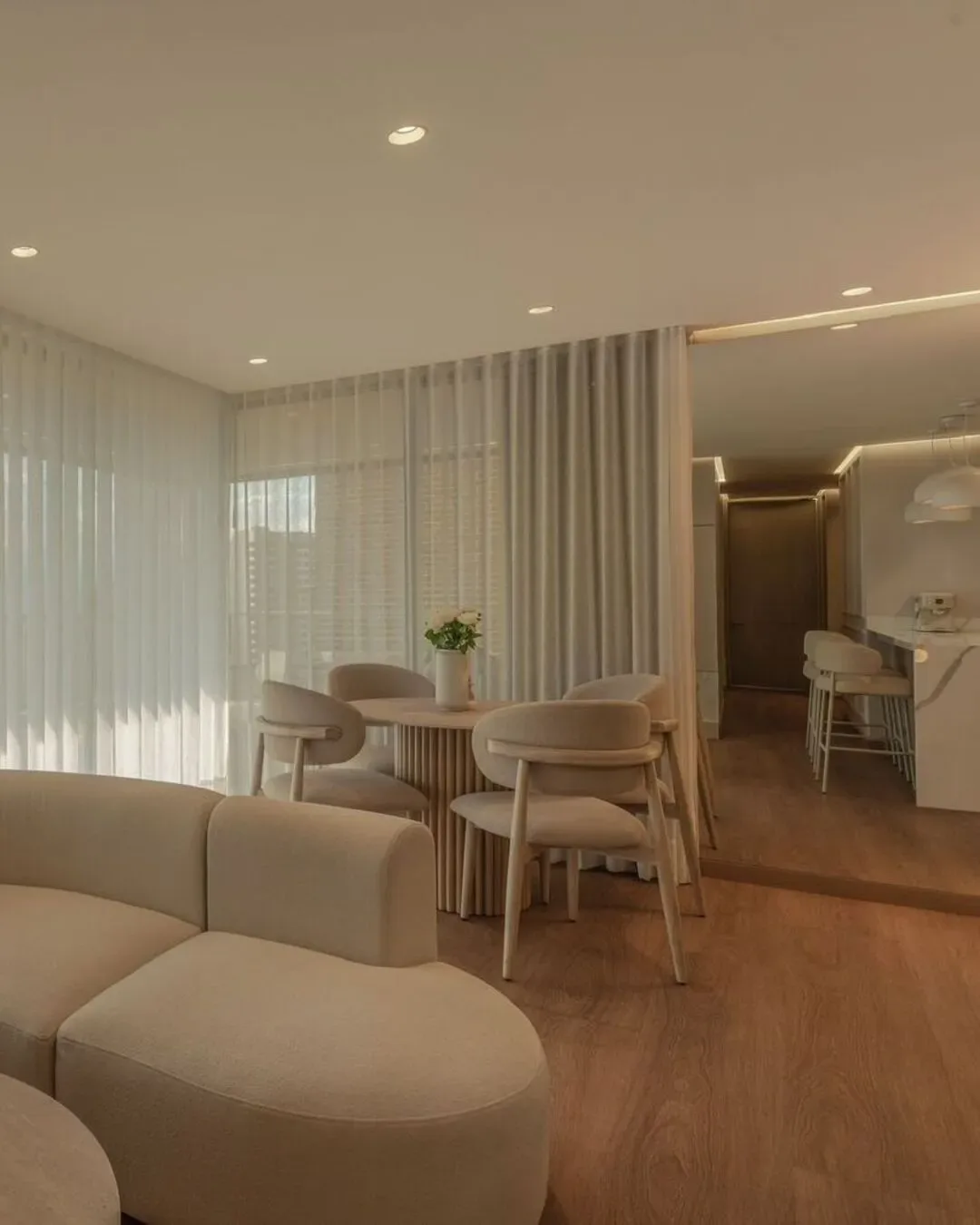 Sala cálida y sofisticada con formas orgánicas, luz suave y diseño contemporáneo.