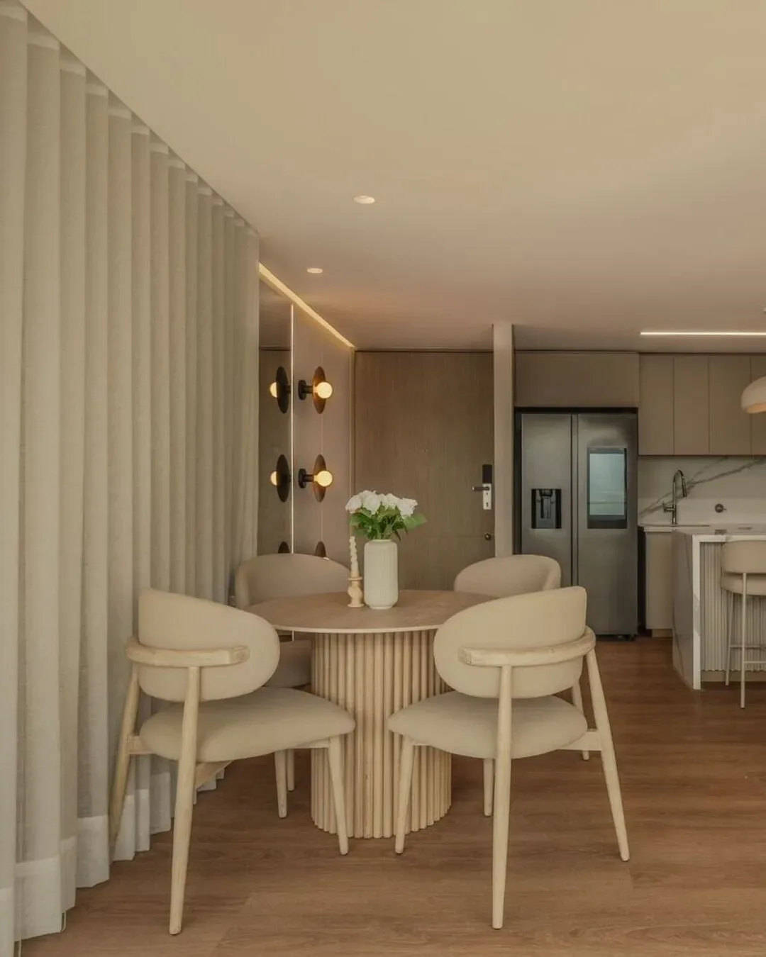 Comedor contemporáneo con formas curvas, materiales nobles y ambiente cálido y luminoso