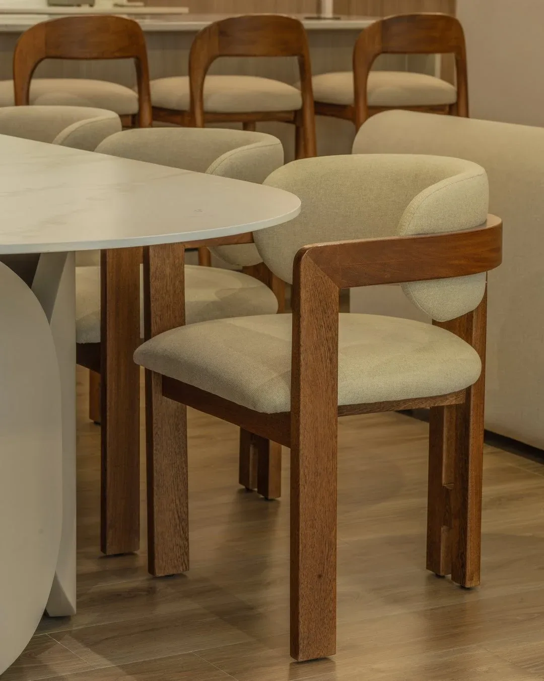 Vista detallada de una silla de comedor con estructura angular de madera maciza y tapicería beige