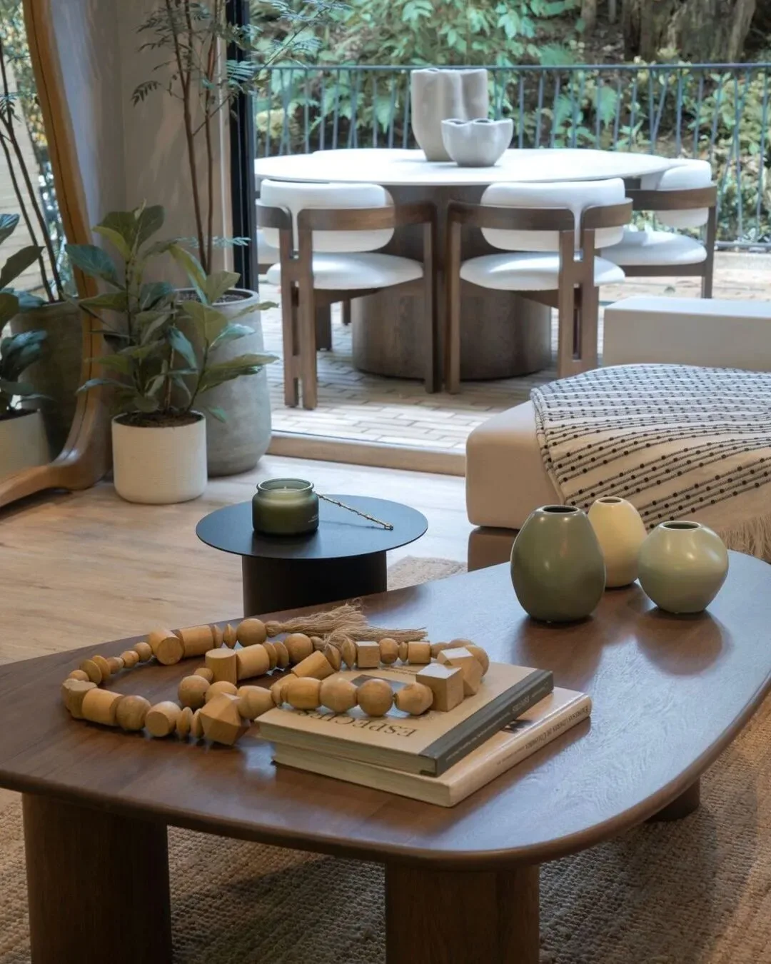 Mesa de centro en madera de forma orgánica con base cilíndrica y mesa auxiliar de acero negro.