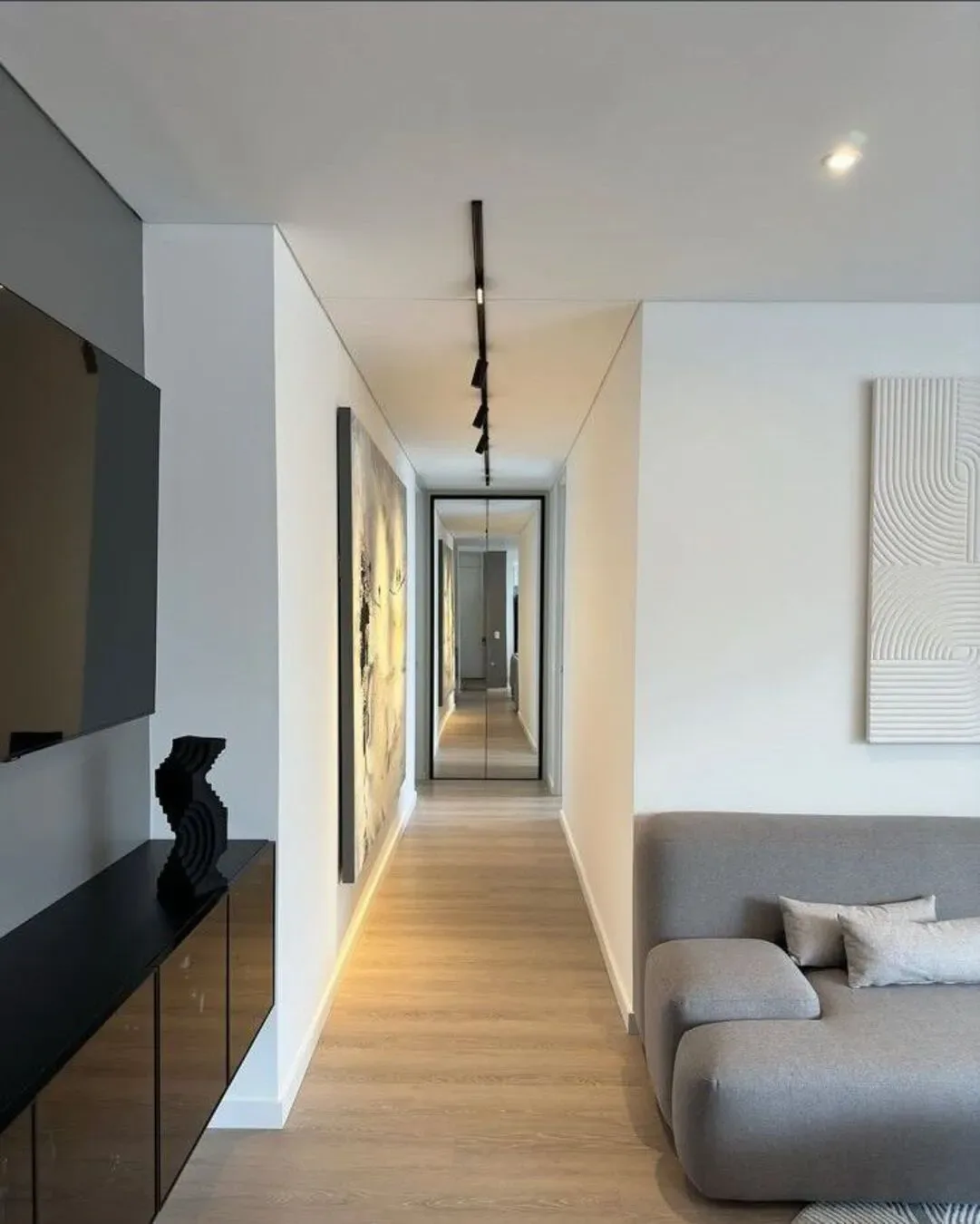 Apartamento sobrio con mobiliario premium, arte, contraste negro y una circulación limpia.