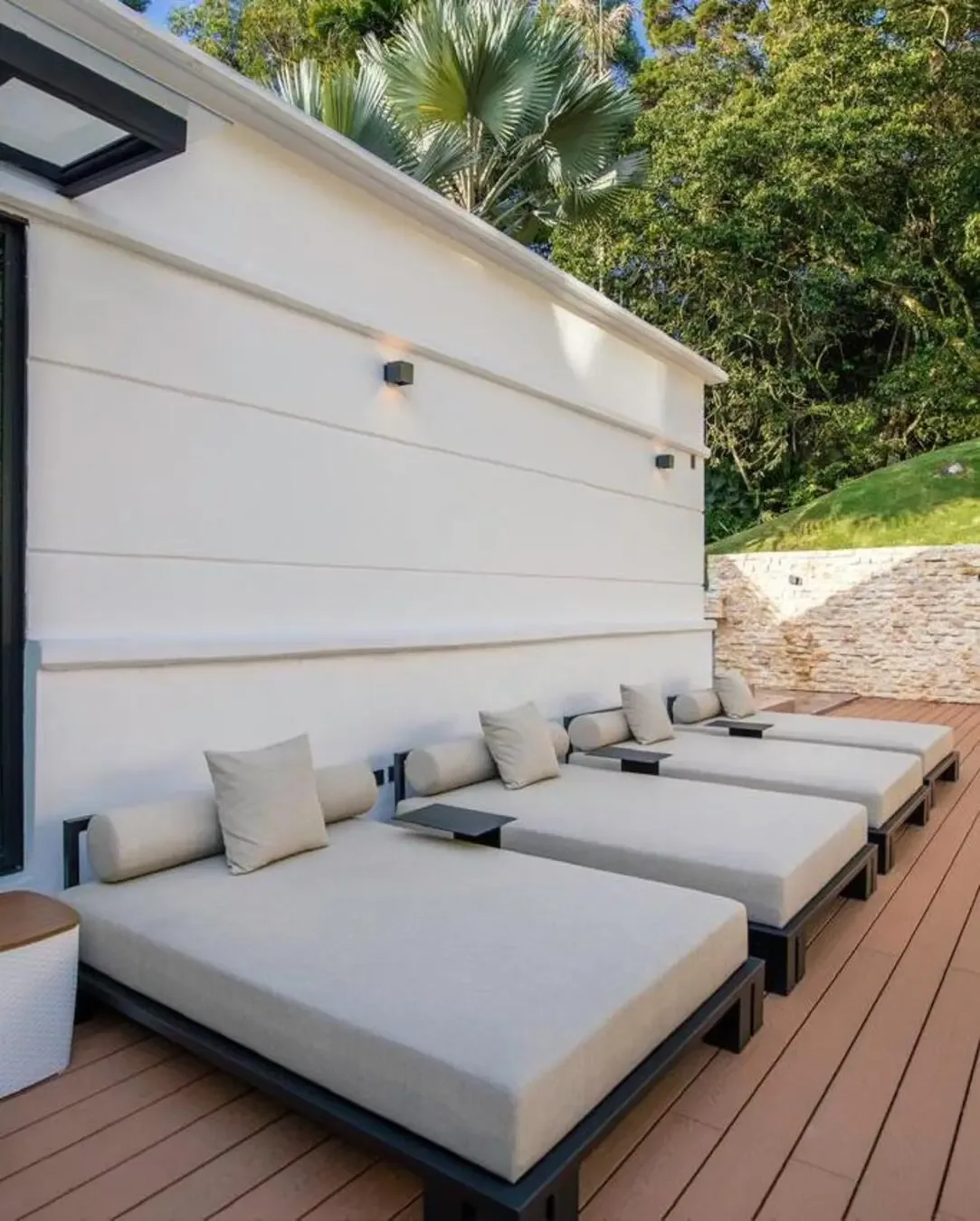 Terraza exterior con camastros acolchados, estructura metálica y ambiente natural para descansar.