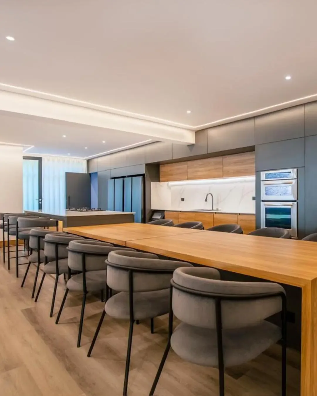 Comedor amplio con sillas tapizadas, mesa en madera y cocina integrada para compartir.Comedor amplio
