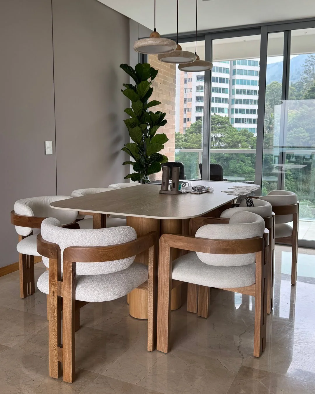 Juego de comedor completo con mesa de piedra y ocho sillas de diseño bajo una luz cálida.